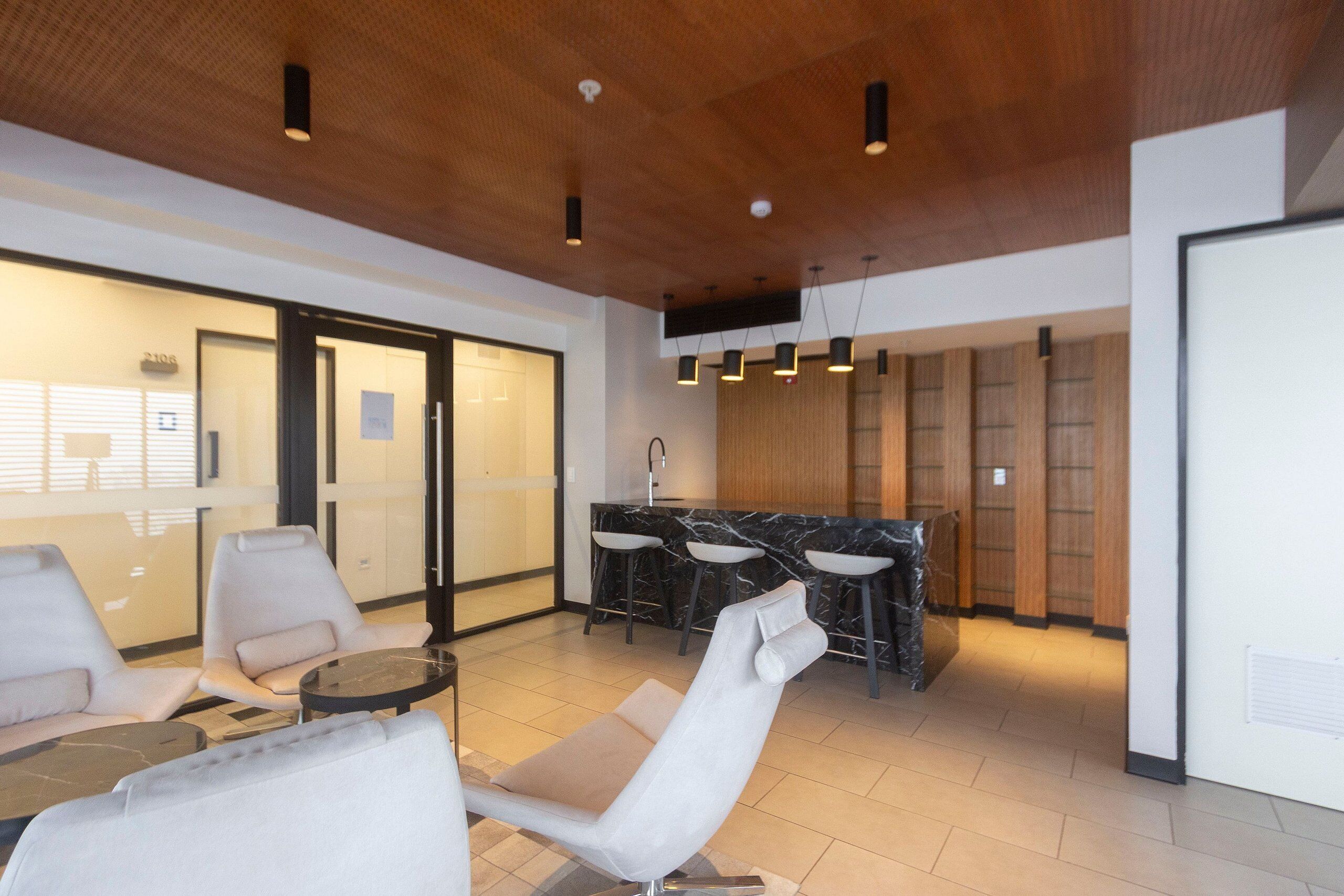 A modern interior with a bar area, seating, and a kitchen.