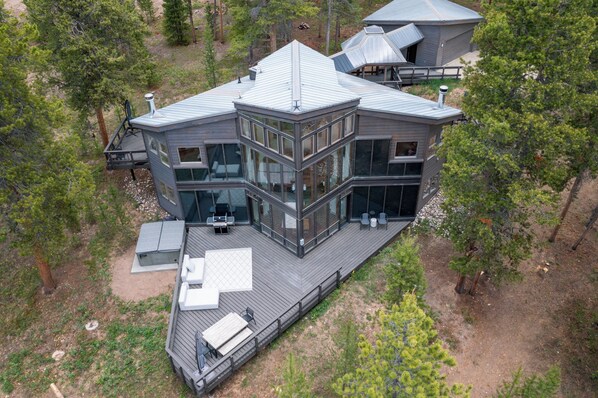A modern, multi-level house with a large deck, surrounded by trees. - Cosmic Cabin at Devil's Thumb 15mins from Winter Park (Fraser)