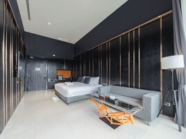 Un dormitorio moderno con cama, sofá, escritorio y silla.