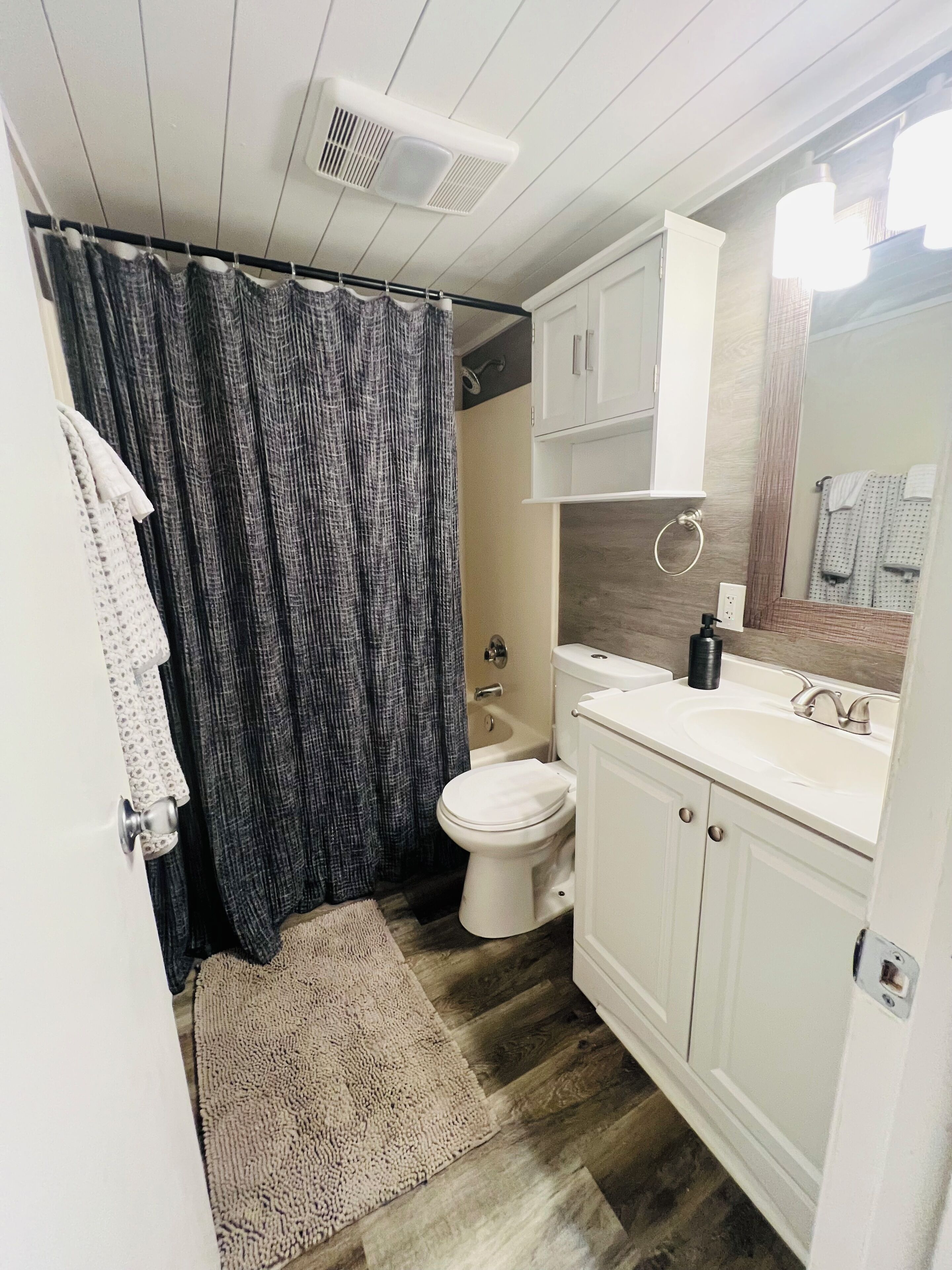 A bathroom with a toilet, sink, and shower.