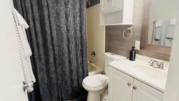 A bathroom with a toilet, sink, and shower.