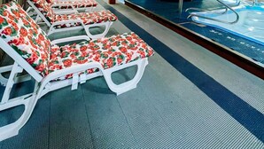 Un área de piscina con sillones de descanso y piscina.