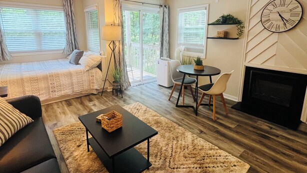 Una sala de estar acogedora con sofá, mesa de centro, chimenea y comedor.