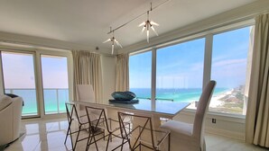 A dining area with a glass table and chairs, a ceiling fan, and large windows with a view of the ocean. - Beachside 2 Sandestin by Gibson BR  (Miramar Beach)