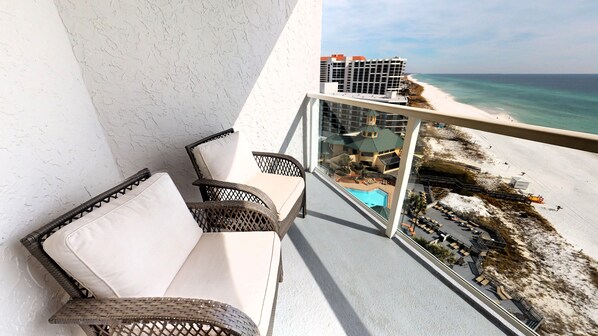 A balcony with wicker furniture overlooking a beach and a pool. - Beachside 2 Sandestin by Gibson BR (Miramar Beach)