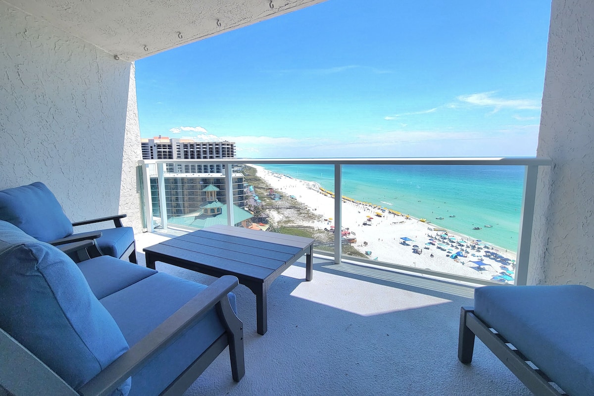 A balcony with a view of a beach and ocean.