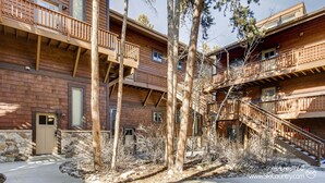 A multi-story wooden building with balconies, a stone entrance, and a clear sky. - Spacious, Multi-Level Home Walking Distance to Slopes, Town & Pool (Breckenridge)