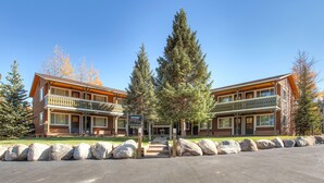 A two-story lodge with a balcony, a stone pathway, and a signboard.