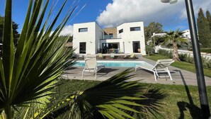 A modern two-story building with a swimming pool, surrounded by greenery and a clear sky. - METERS FROM THE MEDITERRANEAN AMID ST. TROPEZ & ST. MAXIM (Roquebrune-sur-Argens)