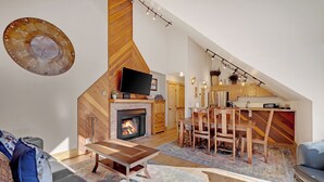 A modern living room with a fireplace, wooden furniture, and a dining area. - Unbelievable Downtown, Walk Everywhere. Pet Friendly! Private Hot Tub! SCC4 (Breckenridge)