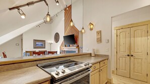 A kitchen with a built-in stove, wooden cabinets, and pendant lighting. - Unbelievable Downtown, Walk Everywhere. Pet Friendly! Private Hot Tub! SCC4 (Breckenridge)
