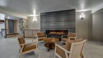 Una sala de estar moderna con chimenea, asientos cómodos y una pared de acento de piedra.