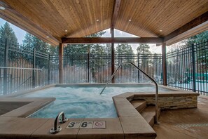 A hot tub area with a wooden ceiling, metal railings, and a view of trees outside. - A Perfect Mountain Getaway On The Slopes near Hiking Trails in Summer TE315 (Breckenridge)
