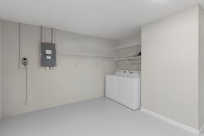 Laundry facilities feature a modern washer and drying rack.