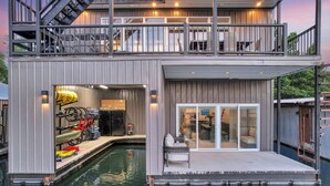 Ett modernt hus med pool, en täckt uteplats och en trappa som leder upp till ett andra våningsplan.