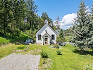 A house with a gabled roof, a front porch, and a gravel driveway. - Smith`s Church House | 1903 | Fireplace | Iconic (Wilmer)