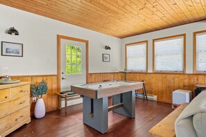 A room with a pool table, wooden cabinets, and large windows with blinds. - Smith`s Church House | 1903 | Fireplace | Iconic (Wilmer)