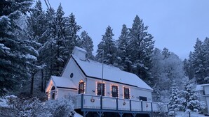A snow-covered house with a balcony, surrounded by trees. - Smith`s Church House | 1903 | Fireplace | Iconic (Wilmer)