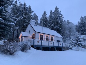 A snow-covered house with a balcony, surrounded by trees. - Smith`s Church House | 1903 | Fireplace | Iconic (Wilmer)