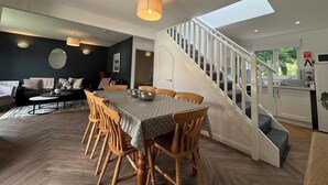 Un vaste espace de vie comprenant une table à manger, des chaises et un escalier menant à l’étage supérieur.