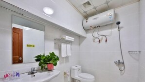A bathroom with a white sink, toilet, and a wall-mounted shower. - Wuzhen Xiangli Xiangqin Homestay (Tongxiang)