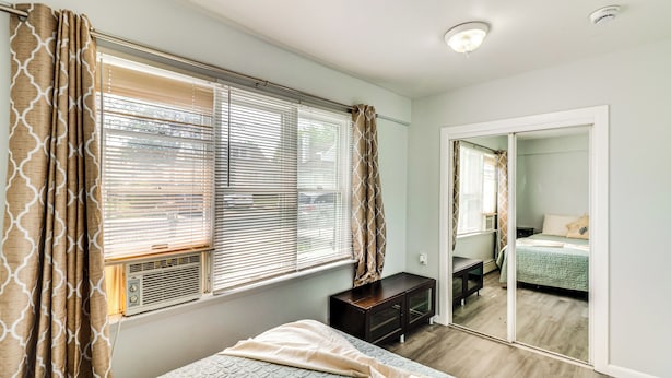 A bedroom with a bed, a dresser, a mirror, and a window with blinds. - Cozy Keansburg Cottage: Walk to Beach & Boardwalk! (Keansburg)