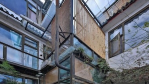 Un edificio moderno con varios pisos, ventanas amplias y fachada de madera.