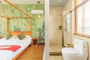 Ein Schlafzimmer mit Himmelbett, floralem Wandpapier und einem kleinen hölzernen Hocker. Das Badezimmer verfügt über eine Dusche mit Glastür und eine Toilette.