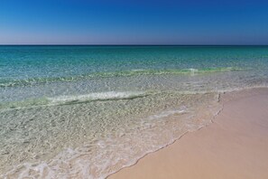 Ein Strand mit klarem Wasser und einem sandigen Ufer.
