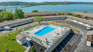Ein Motel mit Schwimmbad, Parkplätzen und Blick auf See und Brücke.