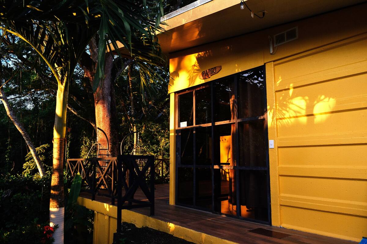 Un bâtiment doté d’une porte de garage, d  ’une terrasse en bois et d’une enseigne sur laquelle on peut lire « PARGO ».