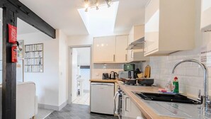A modern kitchen with a dishwasher, washing machine, and a sink with a faucet. - Wesley Chambers By REDWOOD STAYS (Farnborough)