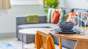 A dining area with a round table, a wooden chair, a black bowl, and a glass of water. - Wesley Chambers By REDWOOD STAYS (Farnborough)