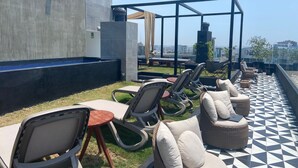 A rooftop terrace with outdoor seating, a water feature, and a view of the cityscape. - Redibuk - Premiere 1BR in San Isidro (Lima)