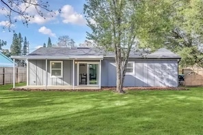 A single-story house with a covered porch, a sliding glass door, and a small attached garage.
