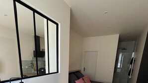 A bedroom with a bed, bedside table, and a desk with a chair. - Appartement Centre Ville (Castelnaudary)