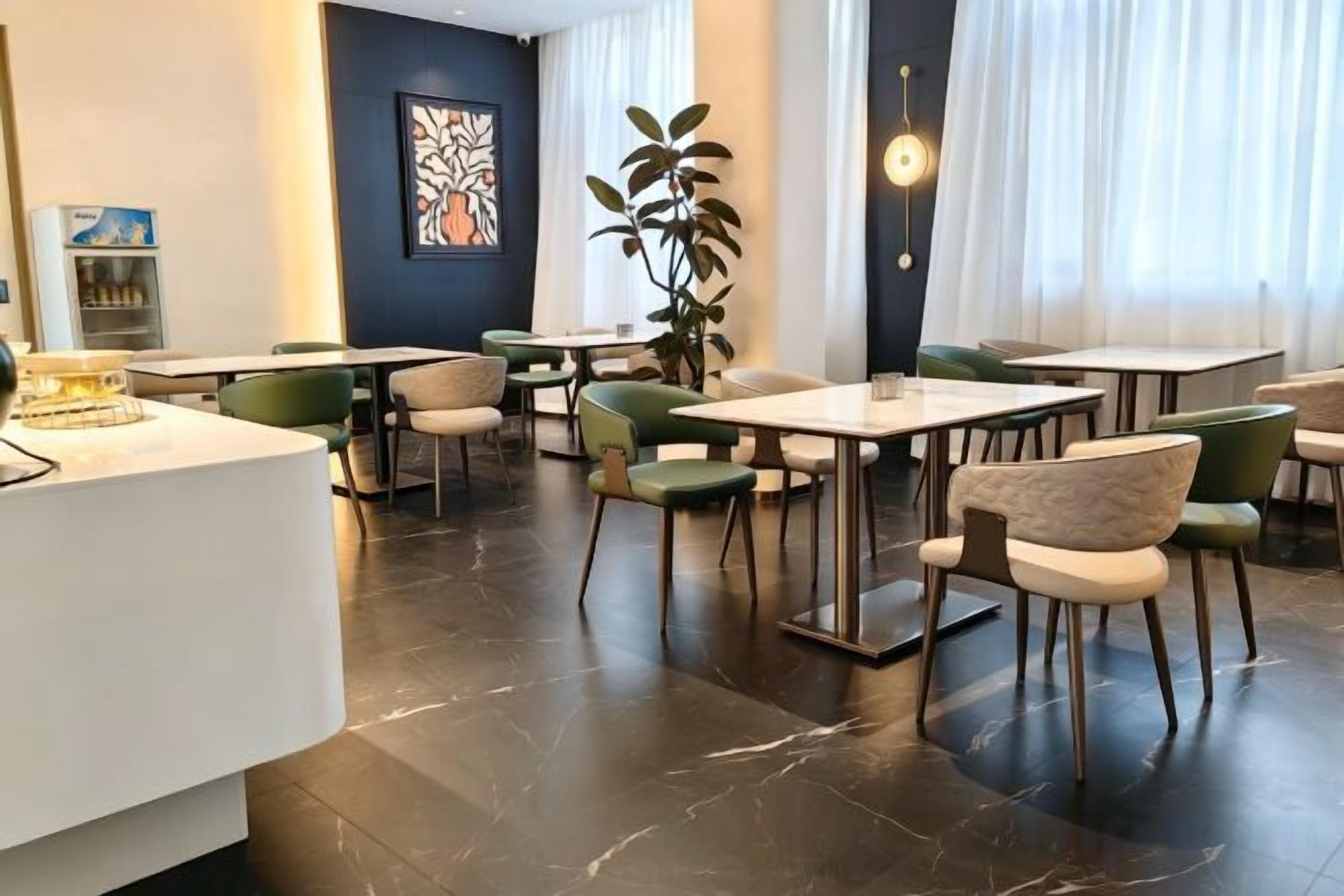 Un moderno vestíbulo de hotel con una recepción, zona de estar y amplias ventanas.