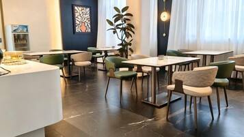 Un moderno vestíbulo de hotel con una recepción, zona de estar y amplias ventanas.