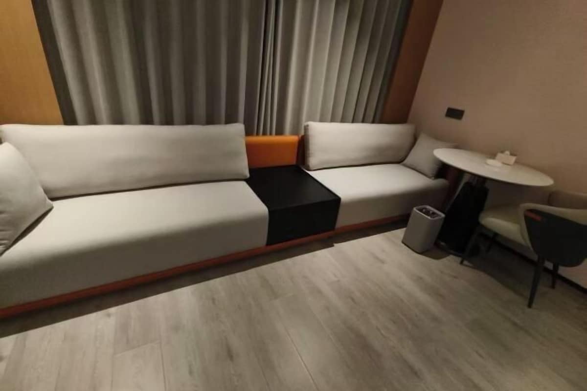 Un saló modern amb un sofà, una taula petita i un safata de brossa.