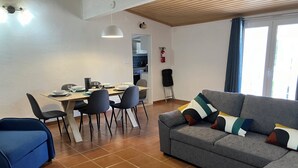 A modern living room with a grey sofa, a dining table with chairs, and a blue couch. - Relax, swim and unwind at this Portuguese house 5 minutes from Sertã, Portugal. (Sertã)