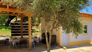 An outdoor patio area with a wooden pergola, a table with chairs, and a grill. - Relax, swim and unwind at this Portuguese house 5 minutes from Sertã, Portugal. (Sertã)