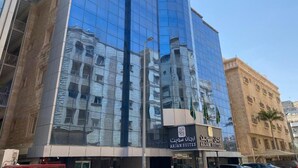 A modern building with a glass facade reflecting nearby structures.
