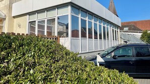 Un edificio moderno con amplios ventanales y fachada blanca.