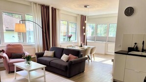 Una sala de estar moderna con sofá, mesa de centro y comedor.