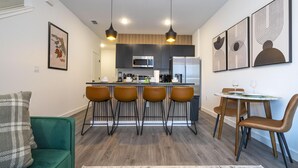 A modern kitchen with a central island, bar stools, and pendant lighting. - 3232 - Beautiful 3br Home near Disney - The Hub at Westside (Kissimmee)