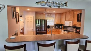 Una cocina con una isla central, armarios de madera y un refrigerador.