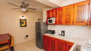 A compact kitchen with a refrigerator, microwave, toaster, and coffee maker.