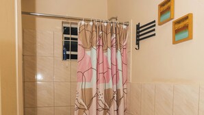 A bathroom with a toilet, sink, and shower curtain.