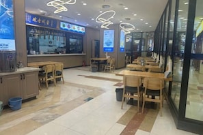 En restaurant med både båsestand og borde, en disk med madvarer og en menutavle.