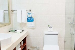 A bathroom with a toilet, a sink, a mirror, and a towel rack. - Xinmei Hotel (Urumqi Hongshan Branch) (Urumqi)